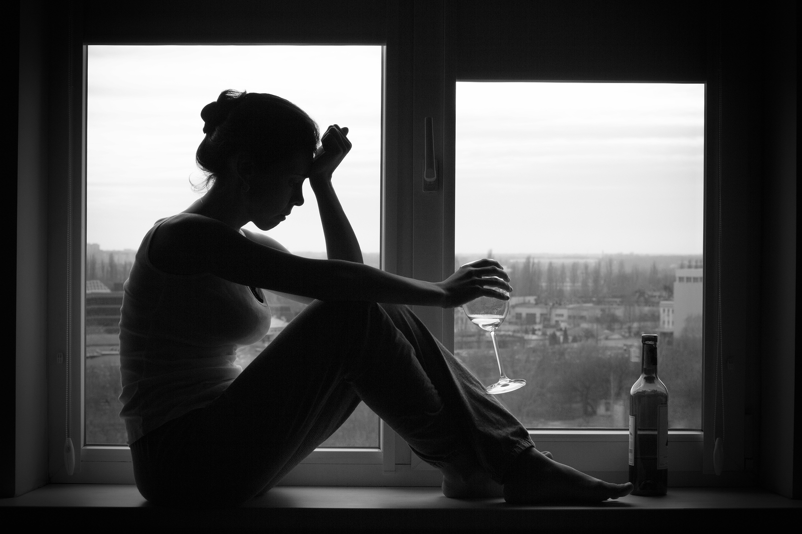 Woman In Depressed Mood Sits On The Window
