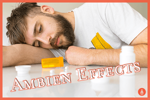 man sleeping on table next to bottle of ambien pills